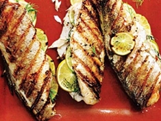 Grilovaná ryba plněná plátky citronů a koprem. Při grilování plněného pstruha se skvěle propojí chutě citrónu a kopru.
