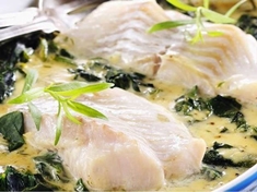 Ryba dušená na špenátu s pikantní smetanou, připravená v troubě.
