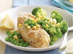 Ryba obalená v rýžové strouhance se zeleninou na másle .
